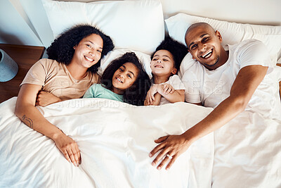 Buy stock photo Top view, bed and family with love, portrait and quality time with happiness, apartment and bonding. Parents, mother and father with children, kids and morning in a bedroom, funny and loving together
