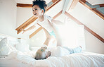Man, young girl in air and games in bedroom, airplane and care free with bonding, love and happiness at family home. Father lifting daughter, playing together with fun and playful, trust and flying