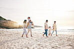 Holding hands, walking and big family at a beach for travel, vacation and fun in nature together. Freedom, parents and children relax with grandparents at the sea at sunset, trip or ocean holiday