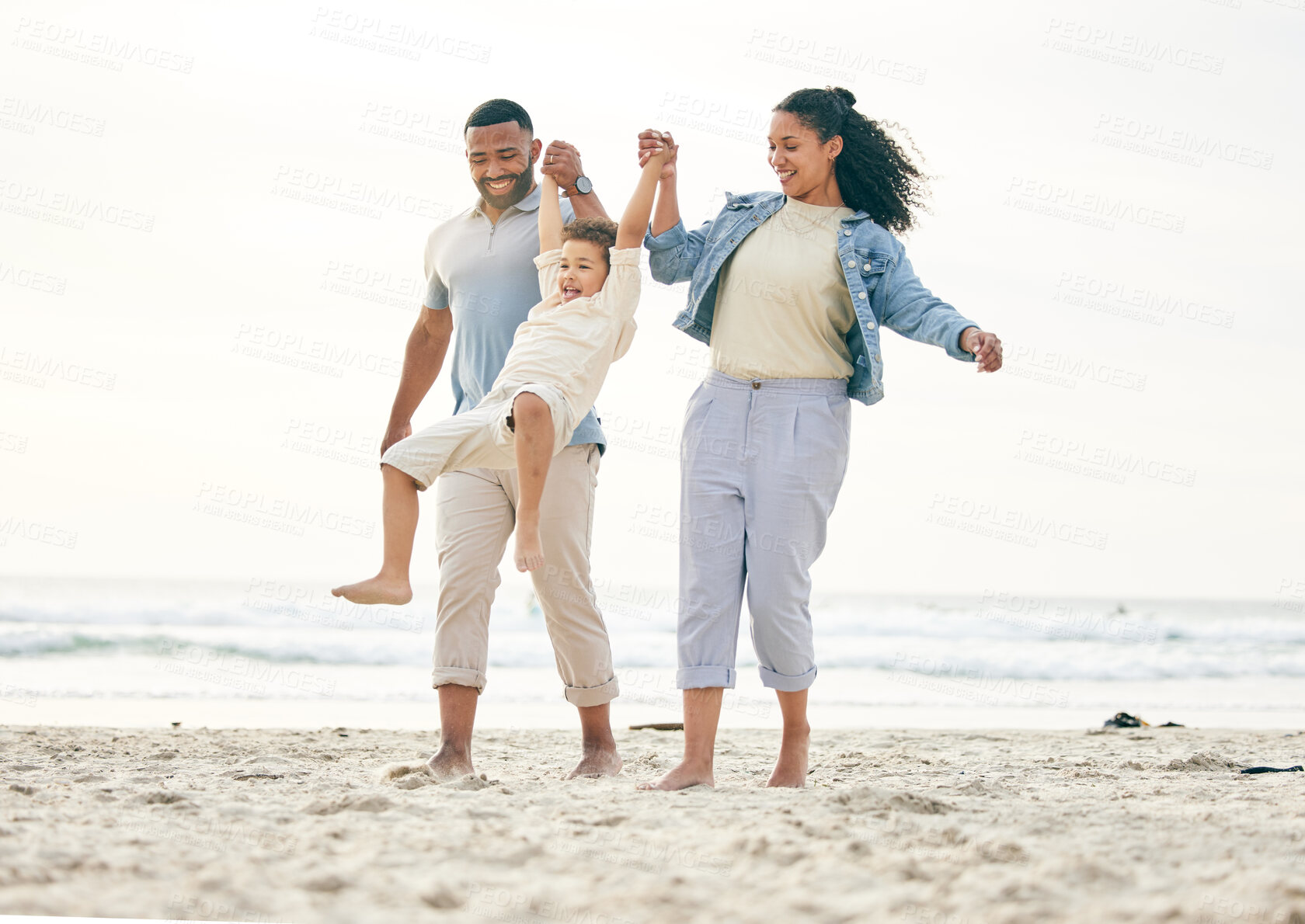 Buy stock photo Beach, family and holding hands outdoor for travel, freedom and bond in nature together. Love, fun and boy child with young parents at the sea with swing game, playing and happy on ocean holiday trip