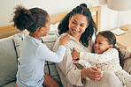 Mother, home and children playing or happy with parent together in the morning laughing in a bedroom on a bed. Funny, bonding and mom enjoy quality time with kids or girls with happiness and love 