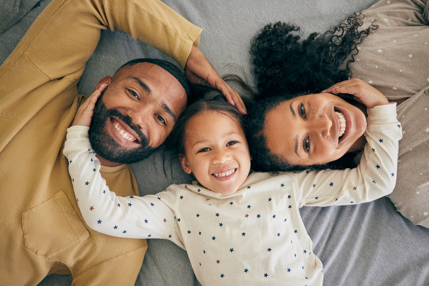 Buy stock photo Happy family, top view and child relax or happy with parents together in the morning laughing in a bedroom on a bed. Smile, mom and dad enjoy quality time with kid with happiness, bonding and love