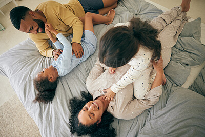 Buy stock photo Happy family, from above and playing in bed in the morning, bond and having fun in their home together. Love, top view and children tickle parents in a bedroom, playful and relax in their house