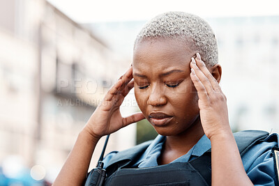 Buy stock photo Black woman, police and headache in stress, anxiety or burnout in the city for justice or law enforcement. Tired female person or officer in pain, depression or overworked in street of an urban town