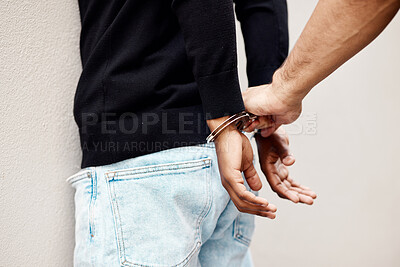 Buy stock photo Man, police and handcuffs of criminal on wall for arrest, crime or justice in theft, robbery or violence. Closeup of male person, officer or security guard cuffing hands of suspect, thief or gangster