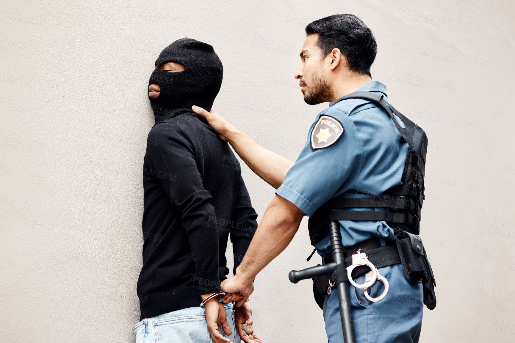 Buy stock photo Man, police and handcuffs on gangster for arrest, crime or justice in theft, robbery or violence. Male person, officer or security guard cuffing hands of robber, thief or criminal against the wall