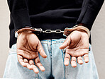 Man, handcuffs and criminal in arrest for crime, justice or theft against the wall of suspect. Closeup of male person, gangster or thief in corruption, violence or fraud for jail, prison or locked up