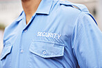 Closeup of security guard, police officer and blue shirt for crime watch, surveillance and legal safety. Person, uniform and service of cop, law enforcement worker and bodyguard on patrol for justice