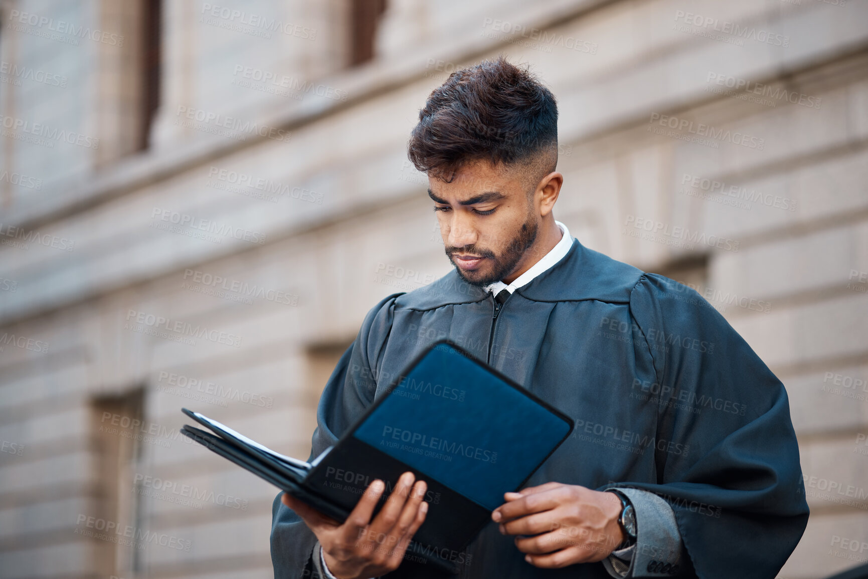 Buy stock photo Legal, research and a lawyer man reading documents on a city street in preparation of a court case or trial. Law, study and information with a young attorney getting ready for a judgement or verdict