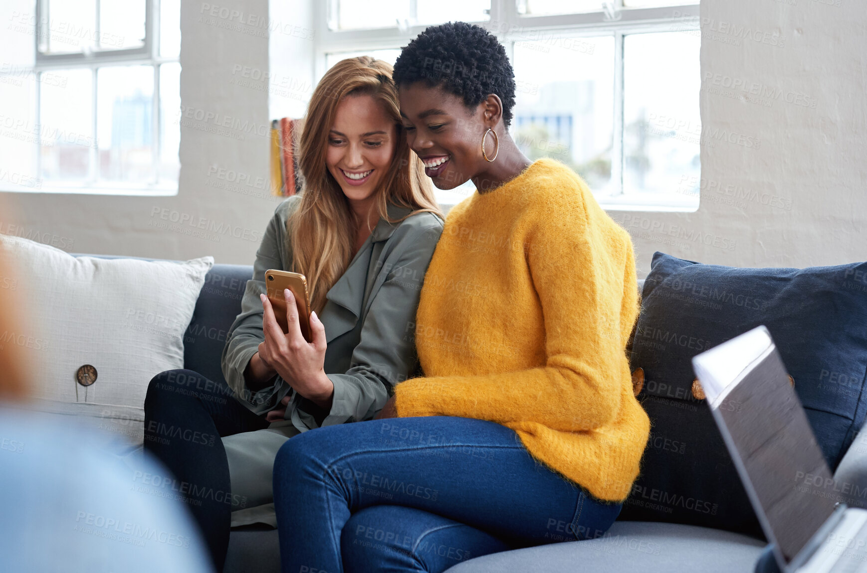 Buy stock photo Phone, diversity and students with women friends sitting on a sofa in the campus breakroom at college. Education, university and young female pupils browsing social media while on break to relax