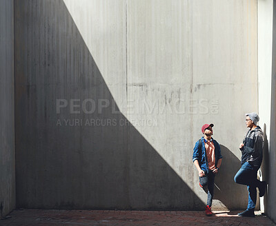 Buy stock photo Fashion, friends and men in a city talking, bond and hanging out on the weekend against wall background. Chilling, conversation and male people downtown for fun, freedom and off day with trendy style