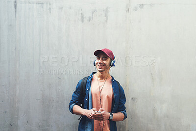 Buy stock photo Man, listening and music with smile in outdoor with concrete wall background for entertainment. Happy, face and guy with headphones is excited with tech for streaming radio with student for sound.
