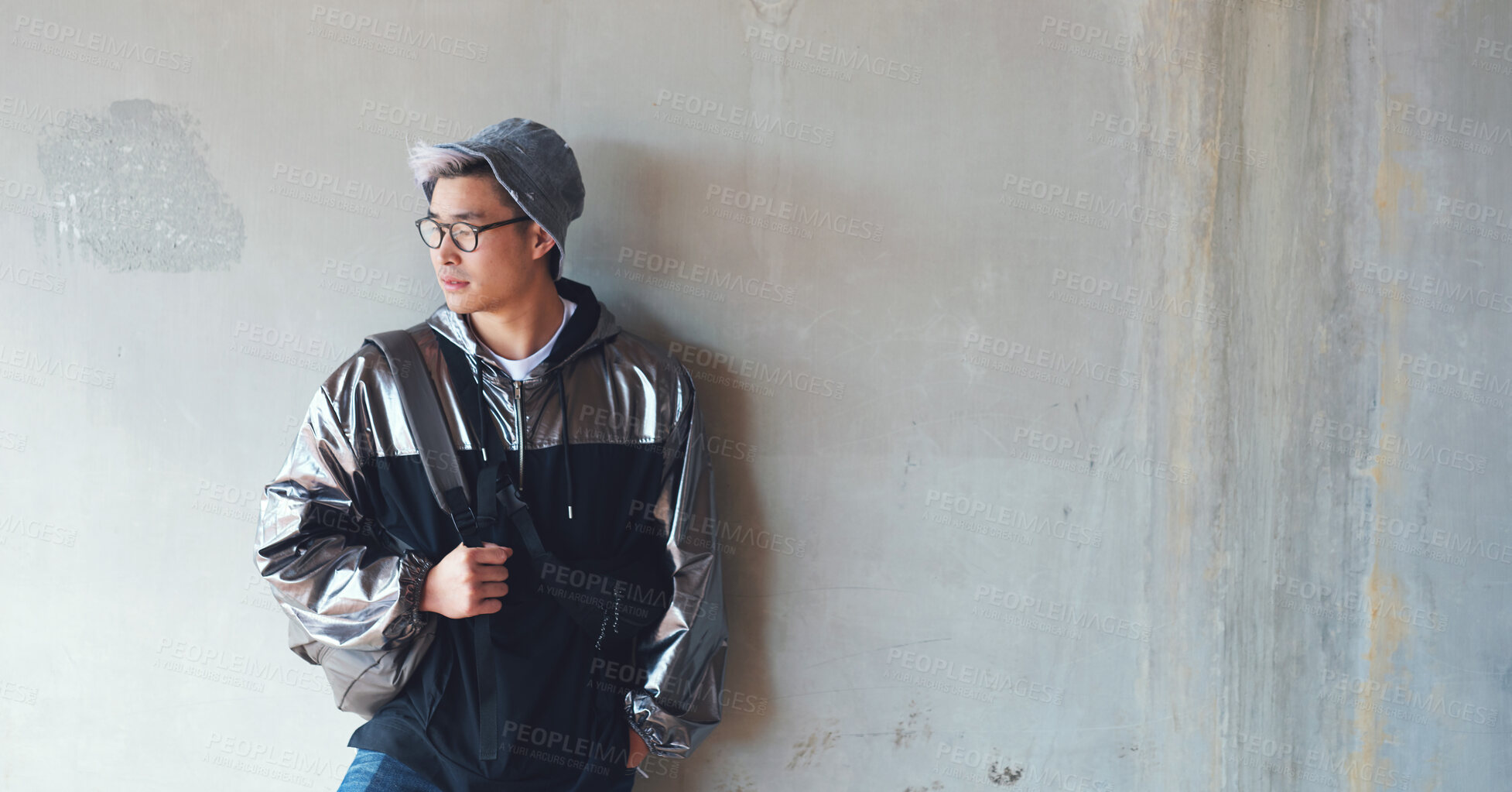 Buy stock photo Fashion, student and gen z asian male streetwear, style and cool clothes on wall background, confident and chilling. Travel, fashionable and Japanese guy outdoors casual, contemporary and stylish