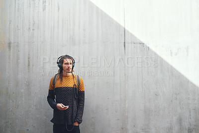 Buy stock photo Man, student and smartphone with headphones and music on university campus, future mindset against wall background. Gen z, education and male person at college, mockup space and listen to podcast