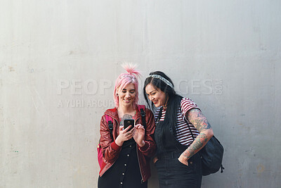 Buy stock photo Friends, cellphone and students, women and wall background with social media and check chat online. Female people on college campus, using phone and mobile app with punk fashion and communication