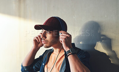 Buy stock photo Man, student with headphones and music on campus, future mindset and audio against wall background. Gen z, education and male person thinking while at college, tech with radio and podcast streaming