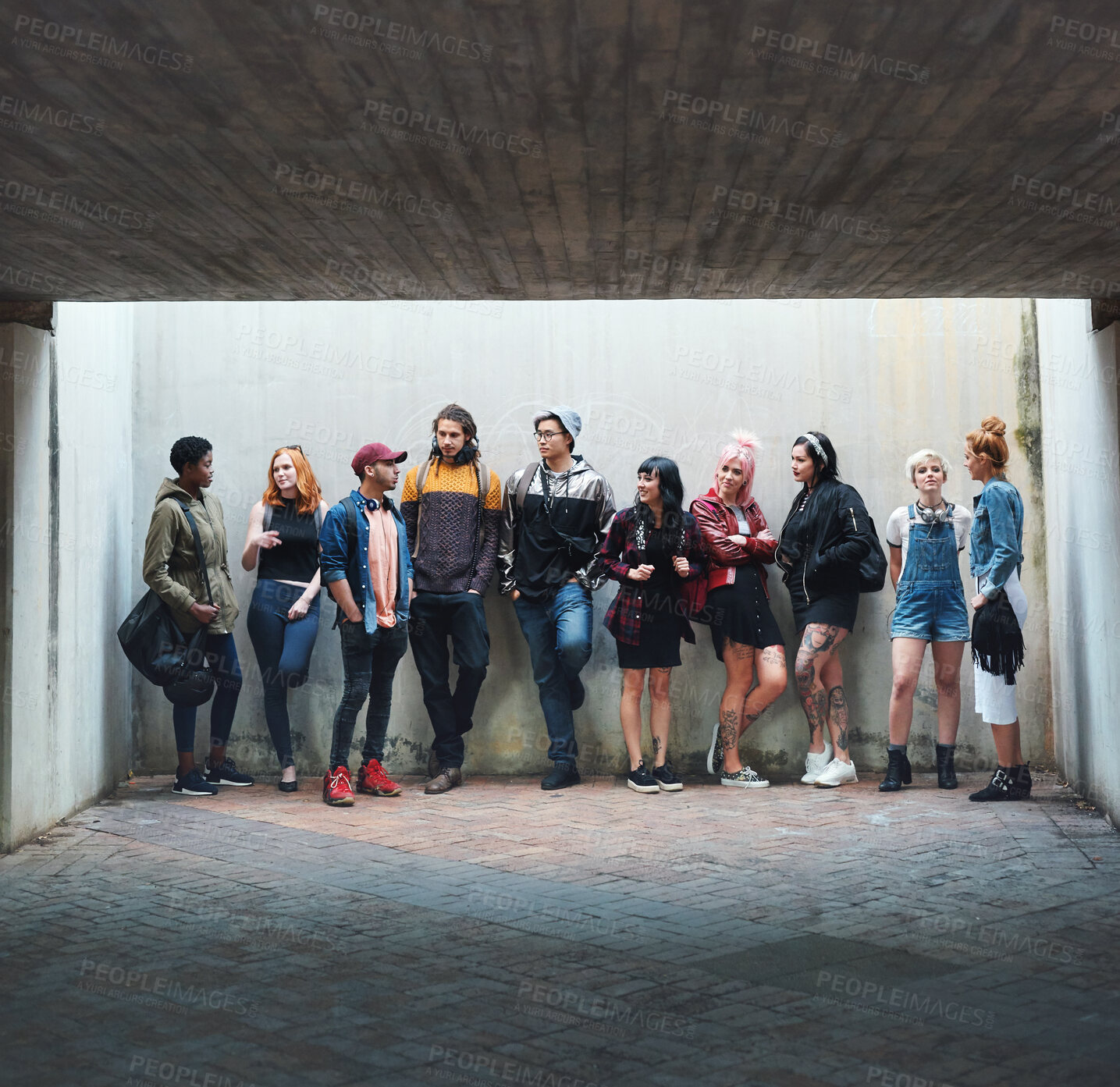 Buy stock photo People, student and friends in relax or social gather standing against a wall in urban town. Diversity or group of creative teenagers hanging out together on college campus with mockup space outside