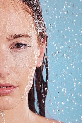 Buy stock photo Closeup, portrait and woman with water, shower or hygiene on a blue studio background. Face, female person or model with drops, liquid or aqua for washing, cleaning or morning routine with wellness