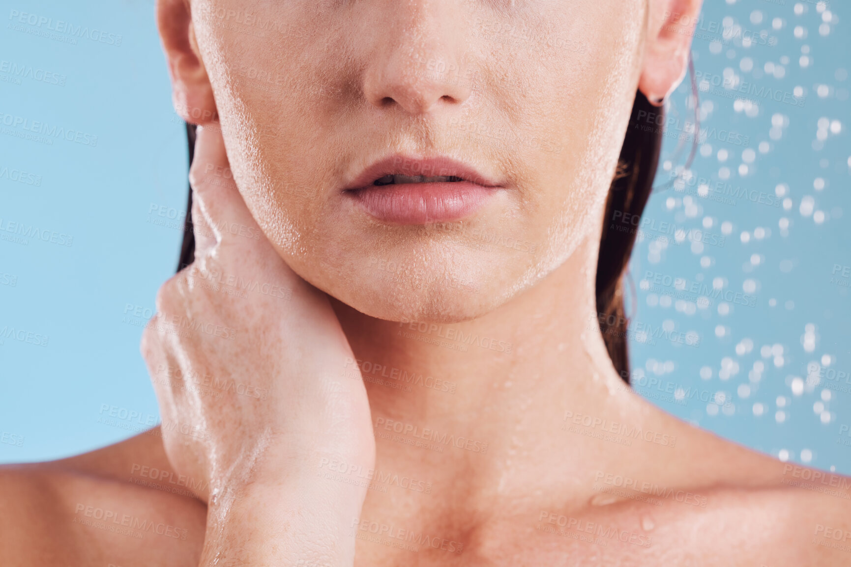 Buy stock photo Woman, hands and shower in water for hygiene, cleaning or self love and body care against a blue studio background. Closeup of female person in skincare, rain or wash for cleanliness or grooming