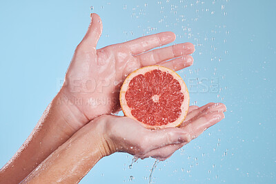 Buy stock photo Hands, water splash and grapefruit cosmetic skincare for vitamin c nutrition, citrus health treatment and natural wellness with hygiene. Aesthetic, advertising hydration and a blue studio background