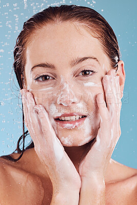 Buy stock photo Woman, hands cleaning face and foam with beauty, shower and hygiene with grooming on blue background. Female model in portrait, sustainability and water drops, dermatology and skincare in studio