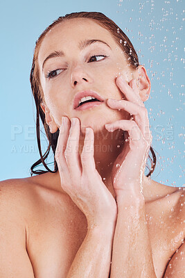 Buy stock photo Skincare, shower and girl with cleaning for self care or hygiene in studio or blue background. Woman, washing and water drops for beauty routine to relax or dermatology for hydration and wellness.