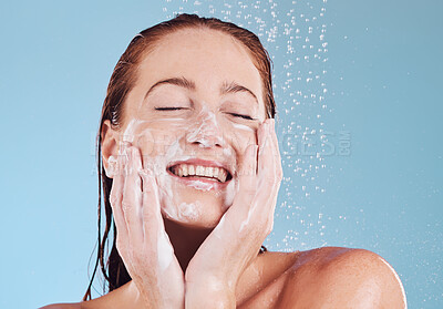 Buy stock photo Happy woman, cleaning face and soap for beauty, shower and hygiene with grooming on blue background. Female model, sustainability and water drop with facial, dermatology and skincare in studio