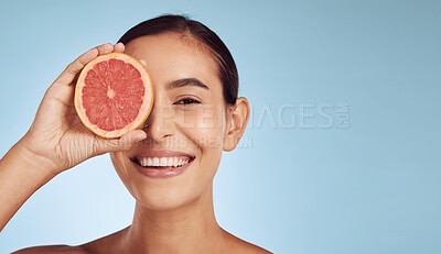 Buy stock photo Woman, skincare portrait and grapefruit on eye for beauty, cosmetics and natural product or vitamin c on banner mockup. Face of person or model and red fruit for dermatology on studio blue background