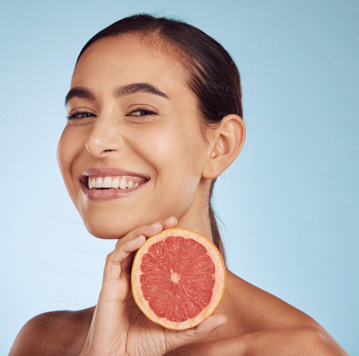 Buy stock photo Happy woman, skincare portrait and grapefruit for beauty, cosmetics, natural product and tropical facial or vitamin c. Face of person or model with red fruit for dermatology on studio blue background