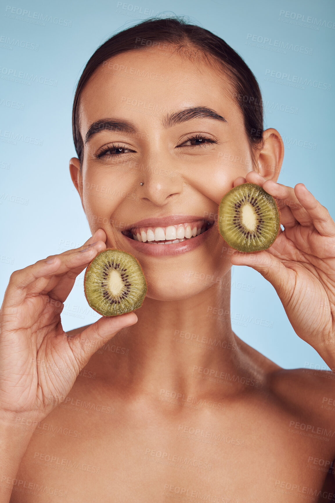 Buy stock photo Beauty portrait, kiwi and woman for skincare, cosmetics and natural product, facial health and vitamin c. Face of young happy person or model, green fruits and dermatology on studio, blue background