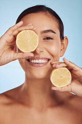 Buy stock photo Happy woman, skincare portrait and lemon for beauty, cosmetics, natural facial product and vitamin c benefits. Face of young person or model with fruits for eye dermatology on studio, blue background