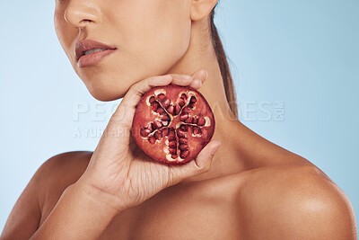 Buy stock photo Face, skincare and hands of woman with pomegranate in studio isolated on a blue background. Natural, fruit and serious model with food for nutrition, healthy vegan diet and vitamin c for wellness.