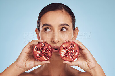 Buy stock photo Face, skincare and woman with pomegranate for beauty in studio isolated on a blue background. Natural cosmetic, fruit and model with food for nutrition, healthy vegan diet and vitamin c for wellness.