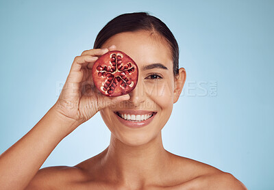 Buy stock photo Woman, beauty portrait and pomegranate for skincare, cosmetics and natural facial product or vitamin c benefits. Face of person or model with red fruits for eye dermatology on studio blue background