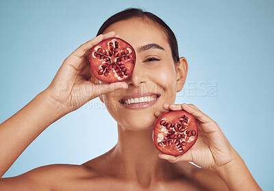 Buy stock photo Woman, skincare portrait and pomegranate for eye beauty, natural cosmetics and facial product or vitamin c benefits. Face of person, red fruits and dermatology or skin care on studio, blue background