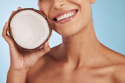 Buy stock photo Happy woman, hands and coconut for skincare, diet or natural nutrition against a blue studio background. Closeup of female person smile with organic fruit for healthy wellness or facial spa treatment