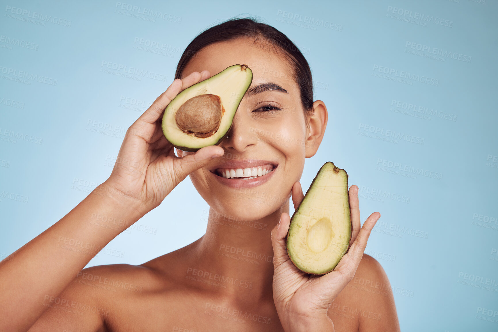 Buy stock photo Avocado, eye beauty and woman in portrait, healthy face and natural skincare on studio blue background. Happy person or model with green fruits, vitamin d benefits and dermatology or cosmetics health