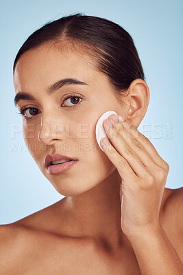 Buy stock photo Woman, face and cotton pad for skincare or makeup removal against a blue studio background. Portrait of female person with swab for cleaning foundation, beauty cosmetics or facial skin treatment