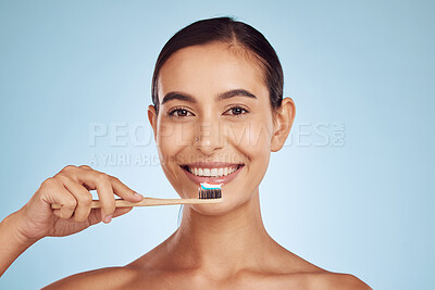 Happy woman, portrait and toothbrush for dental care, health and wellness against a blue studio background. Female person smile with brush for cleaning teeth, oral mouth and gum hygiene in self love