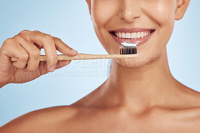 Brushing teeth, toothbrush and woman with dental, hygiene and grooming with oral care isolated on blue background. Female model cleaning mouth, health and morning routine and toothpaste with smile