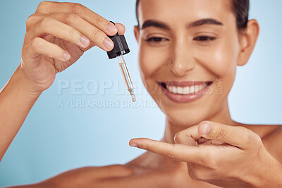 Buy stock photo Smile, skincare and woman with hyaluronic acid on finger isolated on a blue background. Happy, model and hand with serum, cosmetics or collagen for dermatology, essential oil or vitamin c for health