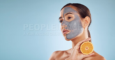 Buy stock photo Mockup, orange and mask for beauty with a woman in studio on a blue background for antiaging skincare. Face, facial and thinking with an attractive young person holding fruit for natural treatment