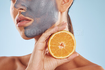 Buy stock photo Closeup, woman and face mask with orange, skincare or dermatology against a blue studio background. Zoom, female person or model with a citrus fruit, vitamin c or beauty with luxury clay or self care