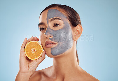 Buy stock photo Woman, orange and face mask for skincare, vitamin C or natural nutrition against a blue studio background. Female person or model with healthy organic citrus fruit for beauty spa or facial treatment