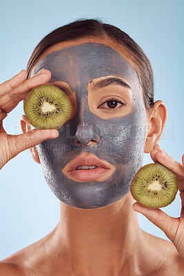 Buy stock photo Portrait, face mask and kiwi with beauty and woman, skincare and eco friendly product on blue background. Charcoal facial, fruit and vegan treatment, female model with skin detox and dermatology