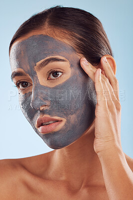 Buy stock photo Face mask, charcoal and beauty of woman as self care, cosmetic or facial treatment isolated in blue studio background. Skin, skincare and young female person clean, hydration and dermatology cream