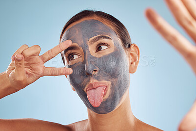 Buy stock photo Skincare, face mask and selfie of woman for beauty, cosmetics or charcoal, clay facial for skin care on studio background. Funny, emoji pose and girl with hand, peace sign and dermatology or spa