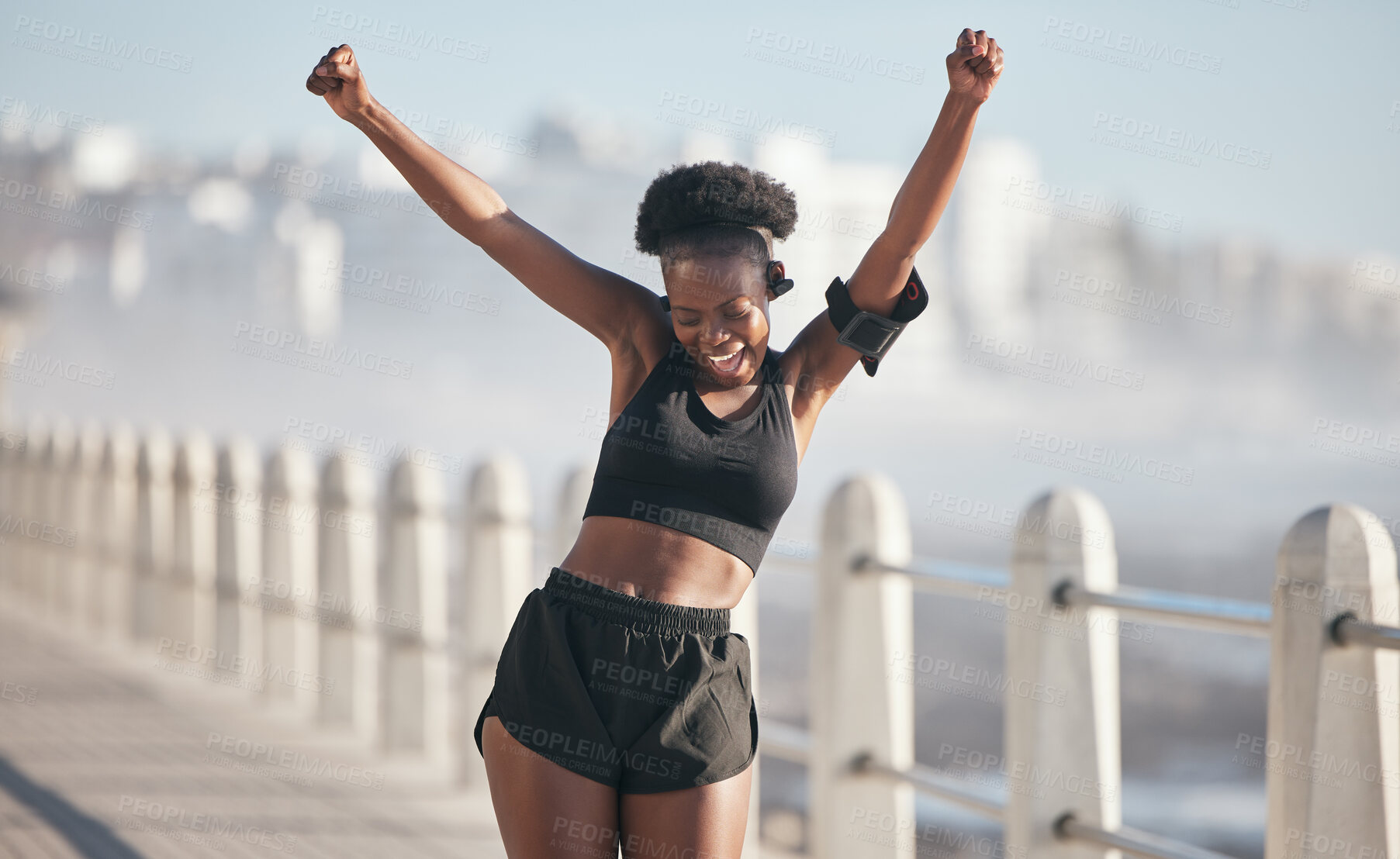 Buy stock photo Happy woman, dance and fitness success by city beach in energy, exercise and cardio health with music technology. Listening, training and celebration, winning or yes of african person or runner goals