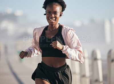 Buy stock photo Portrait, running and black woman outdoor with earphones for audio, radio music and podcast. Sports, fitness and happy African athlete training, workout and exercise for health, wellness and cardio