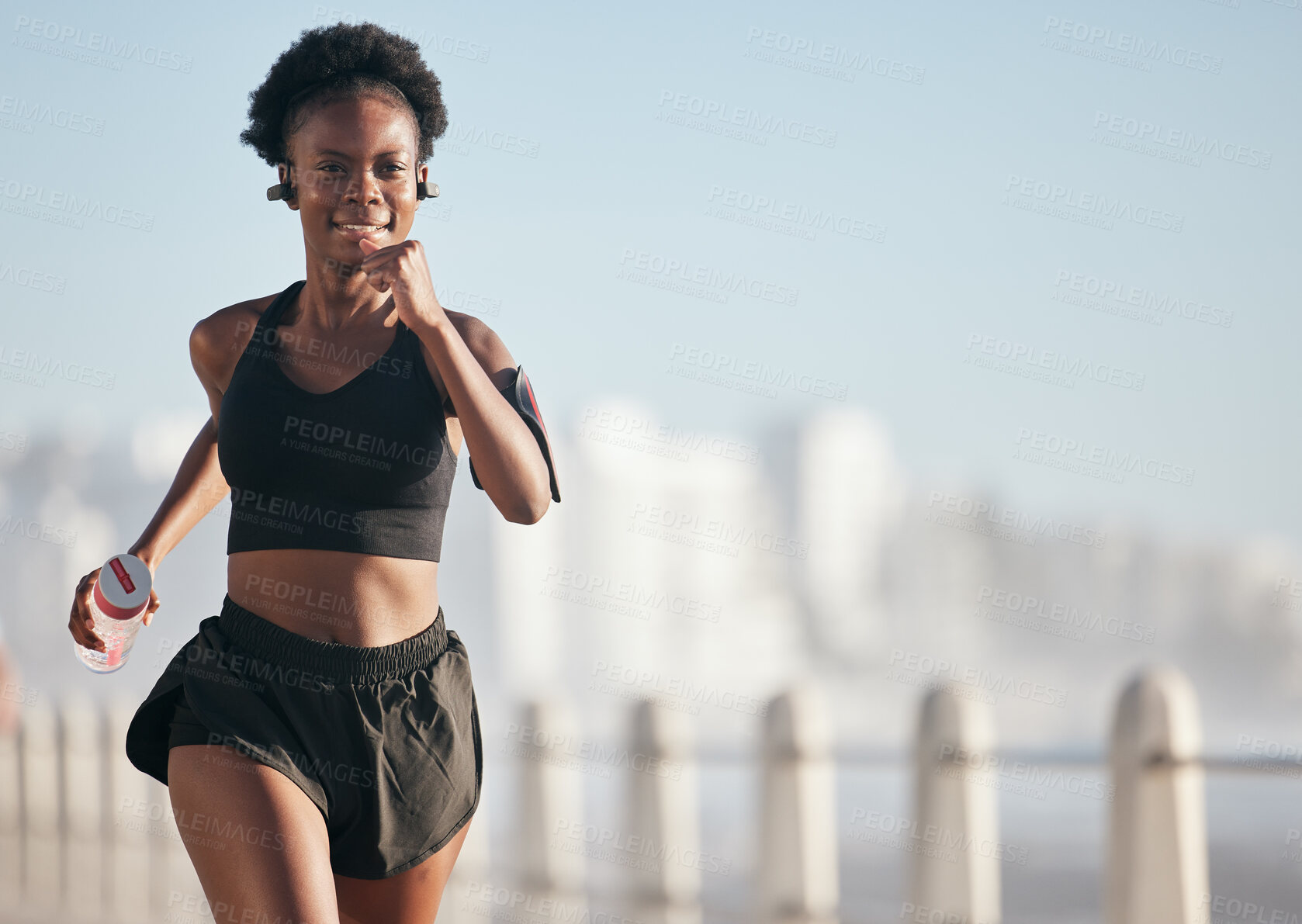 Buy stock photo Running, happy and black woman outdoor with music earphones for radio, podcast and mockup space. Sports, fitness and African athlete smile, workout or training exercise for health, wellness or cardio